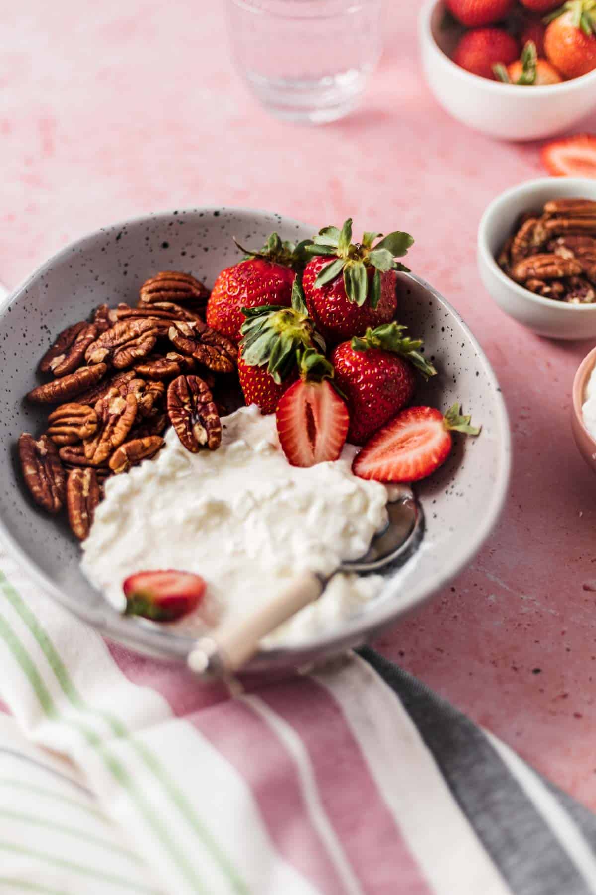 Close up image of hunger crushing combo snack of strawberries, pecans, and cottage cheese in a bowl. 