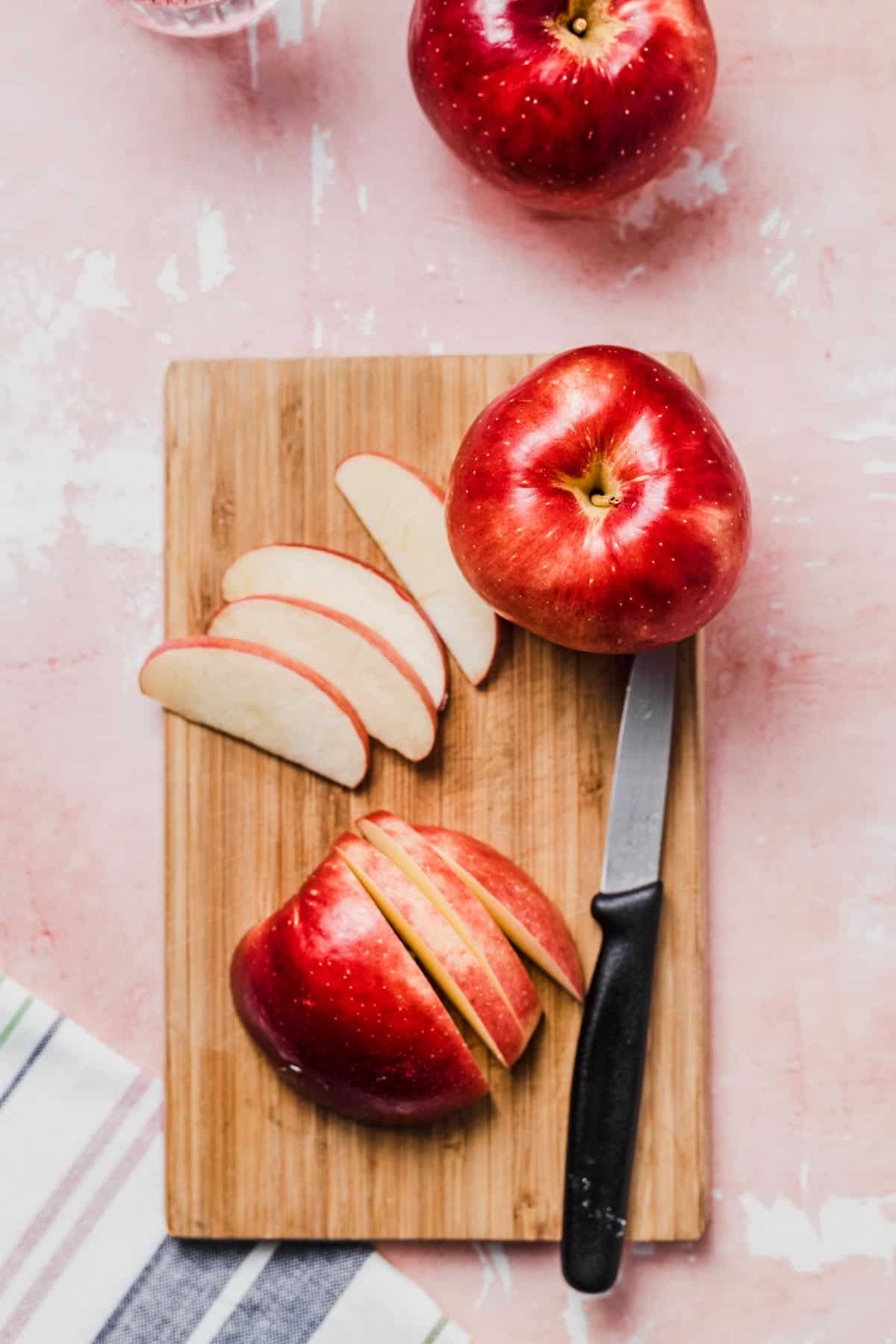 Birds eye view of sliced apple on a cutting board.