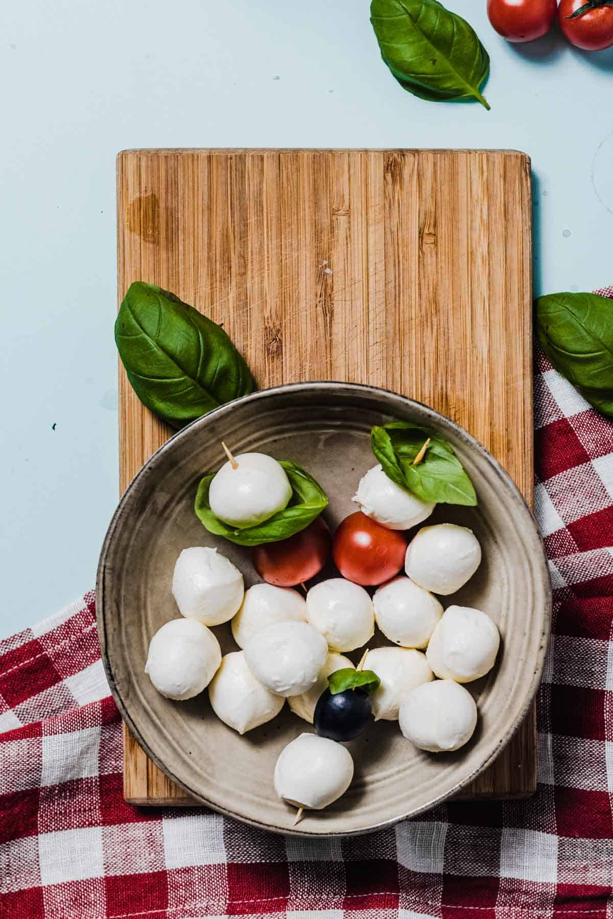 Birds eye view of mozzarella cheese balls in a grey plate. 