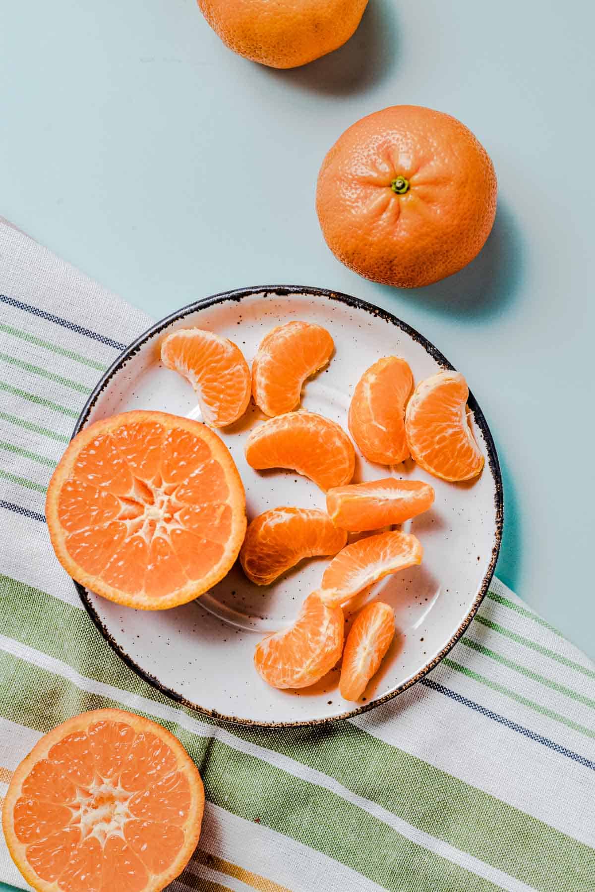 Birds eye view of mandarin oranges on a white plate.