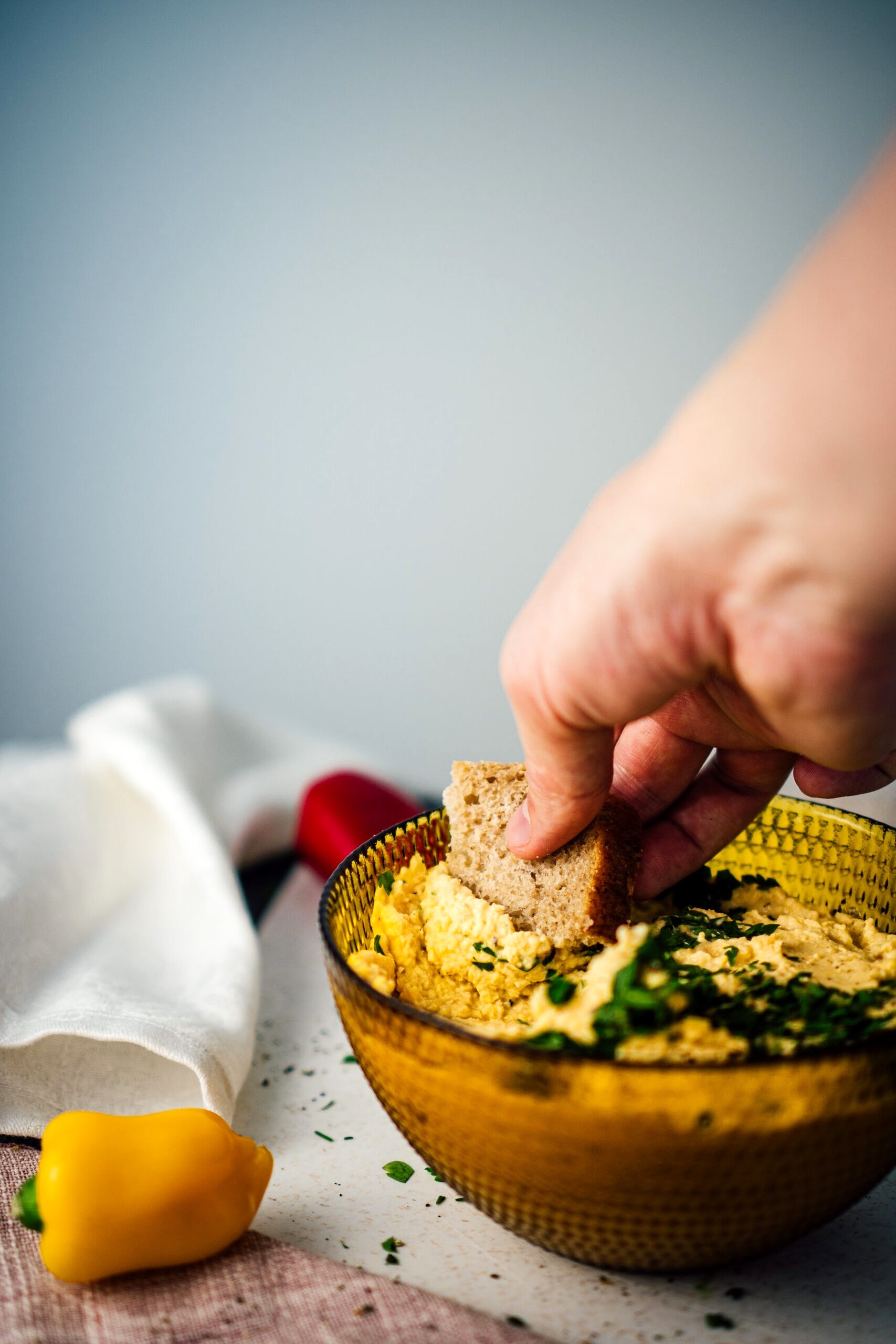 Hand dipping bread into a dip.