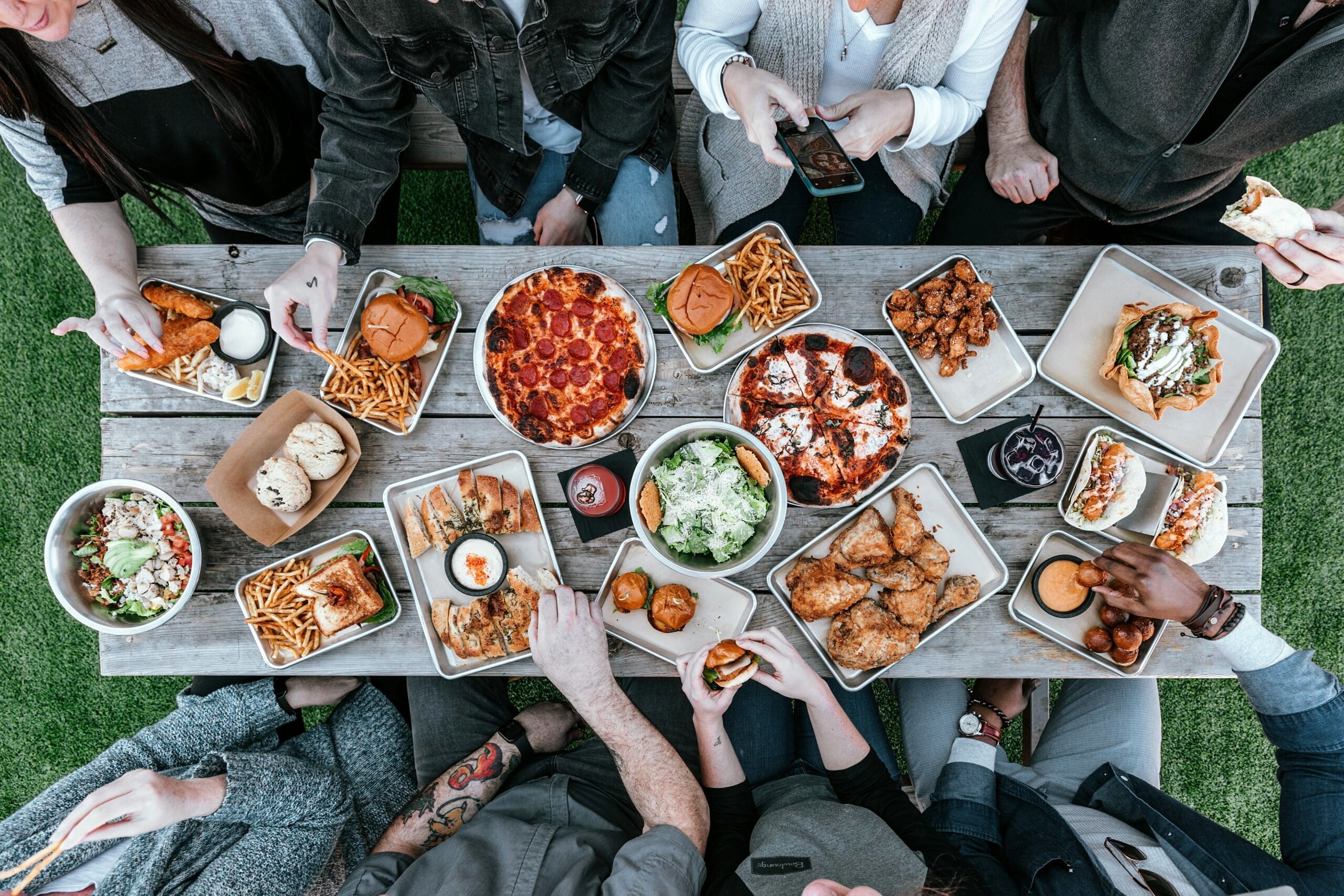 Birds eye view of a group of people eating around a table with food.
