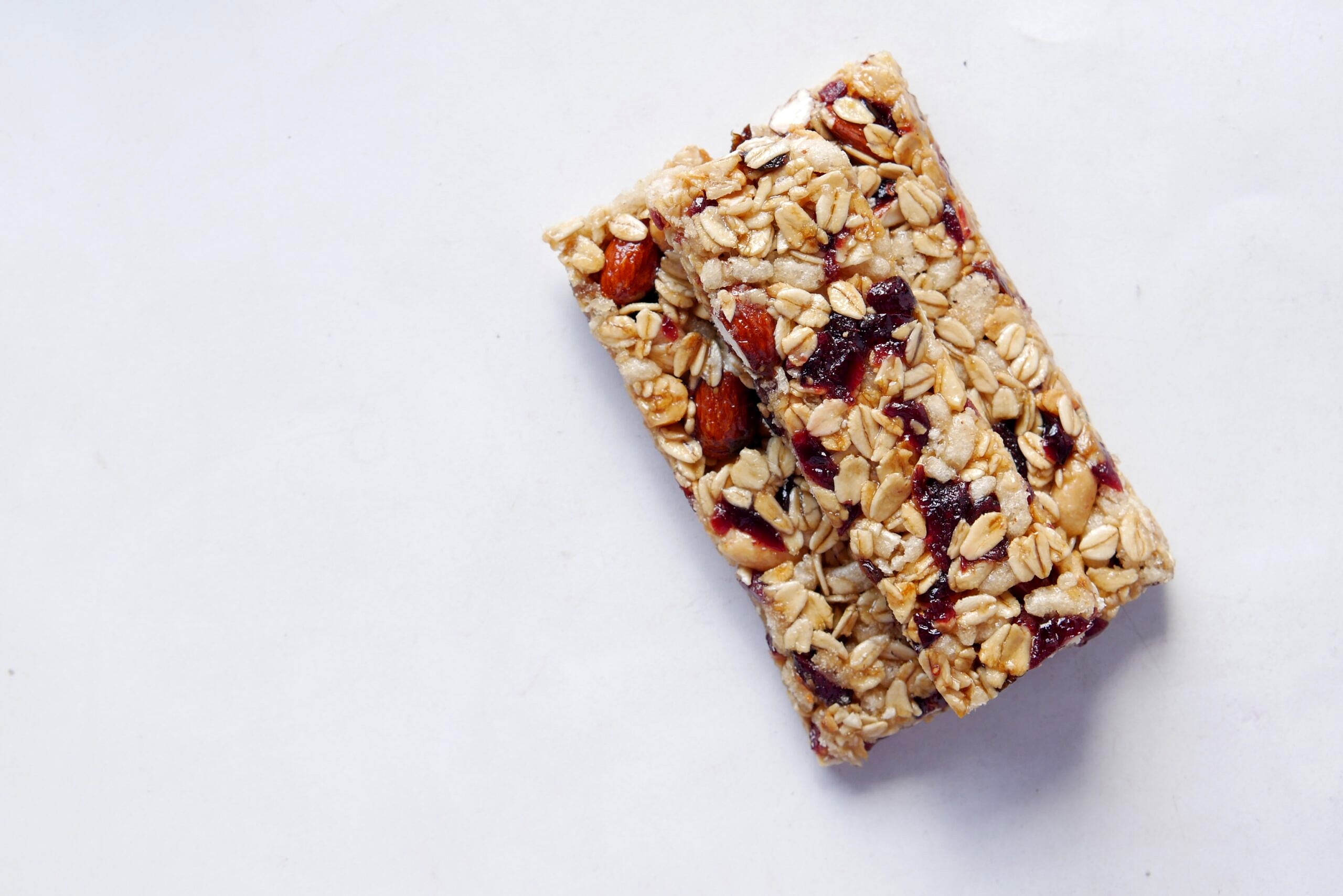 Two granola bars against a white background as a tip to gain weight.