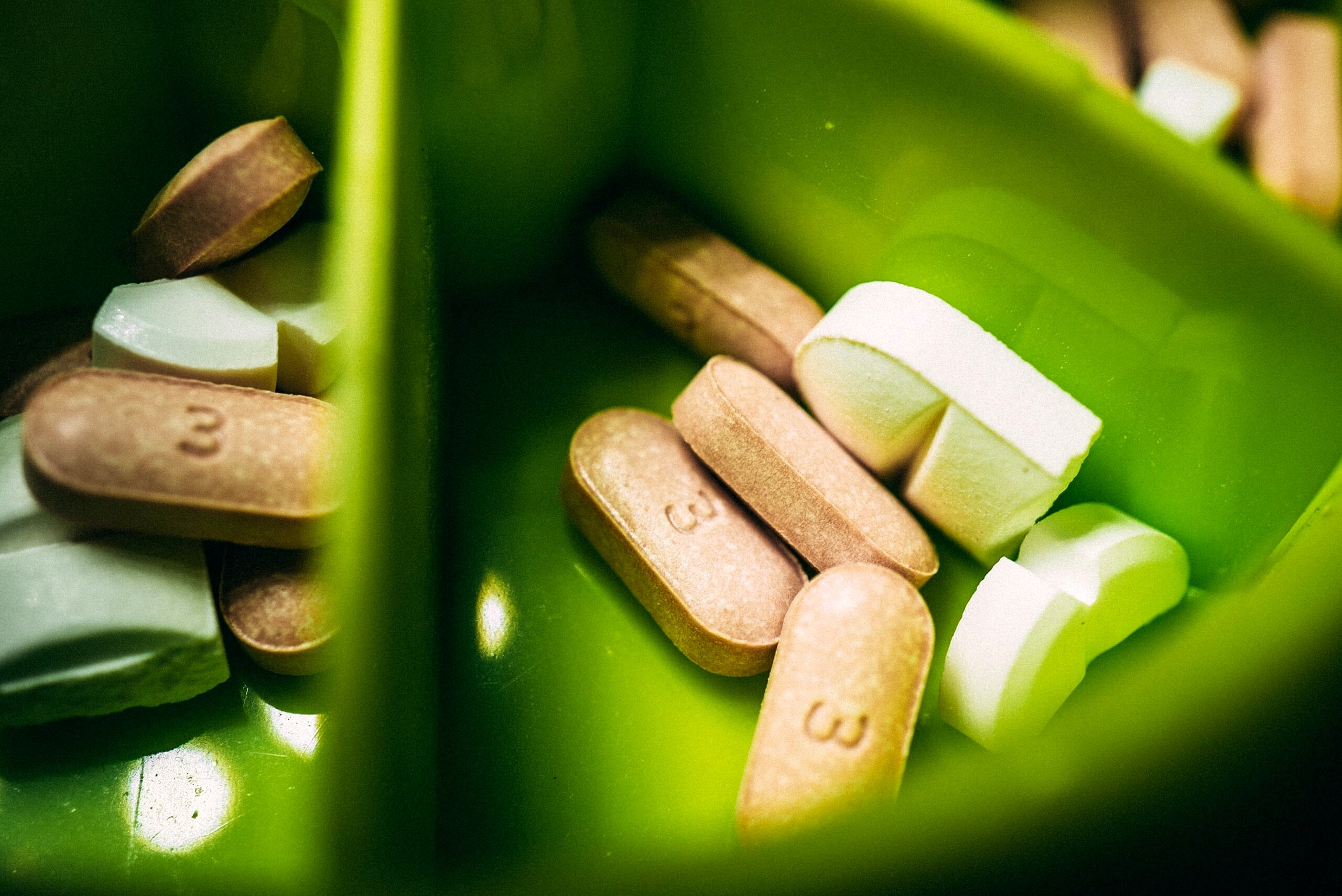 Close up image of digestive supplements in a green bowl.