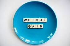 Blue plate with letters spelling "weight gain".