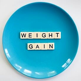 Blue plate with letters spelling "weight gain".