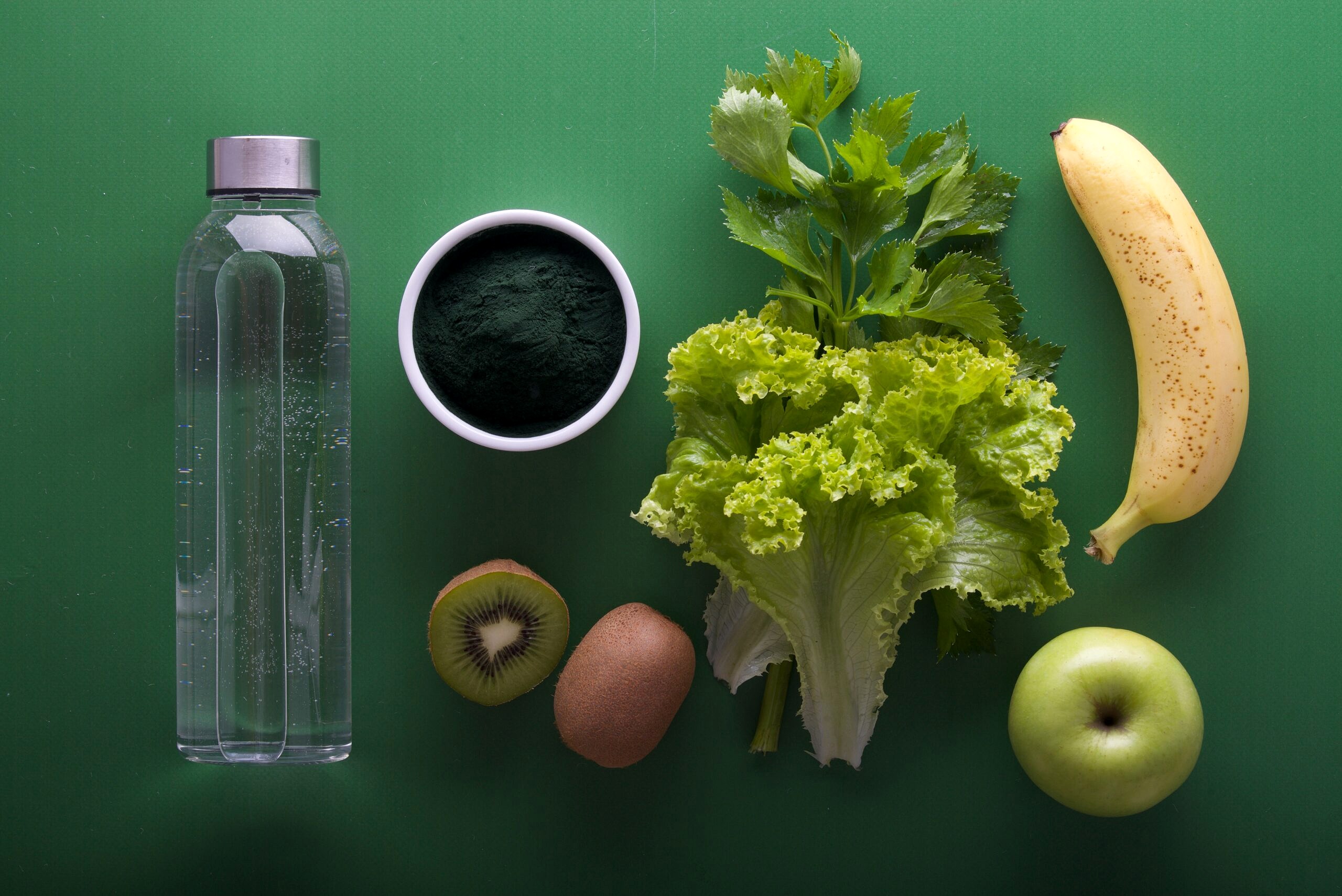 Various fruits and vegetables on a dark green background.