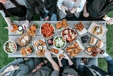 Birds eye view image of people eating around a table.