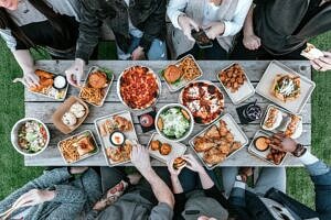 Birds eye view image of people eating around a table.