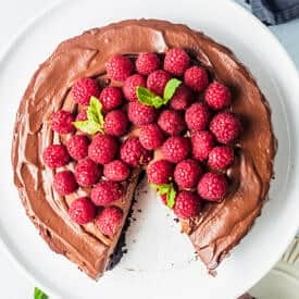 Chocolate cake on a plate with raspberries.