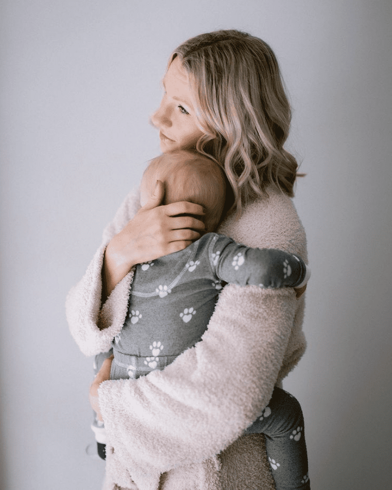 Woman holding her baby to discuss postpartum anxiety.