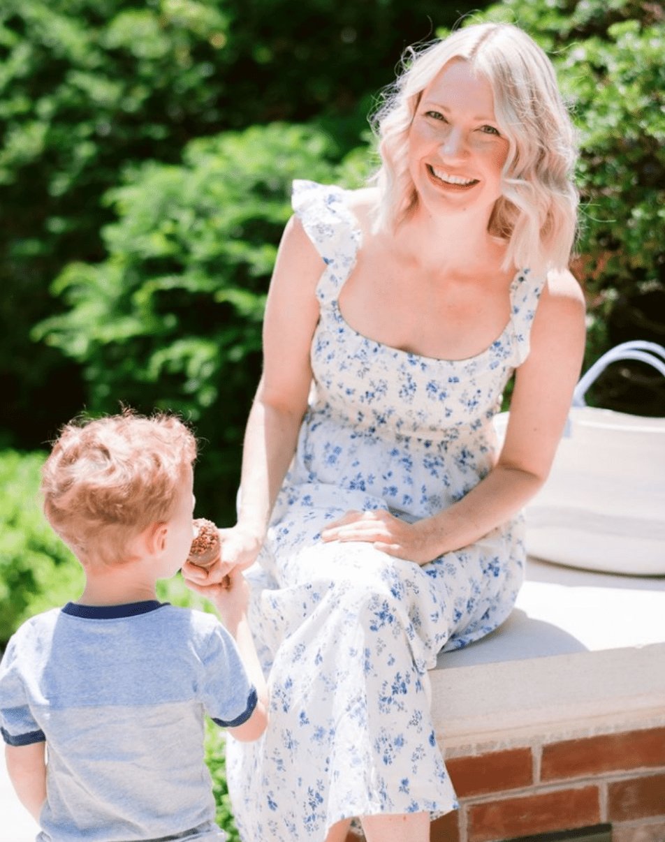 Mom smiling and feeding child ice cream to relieve postpartum anxiety.