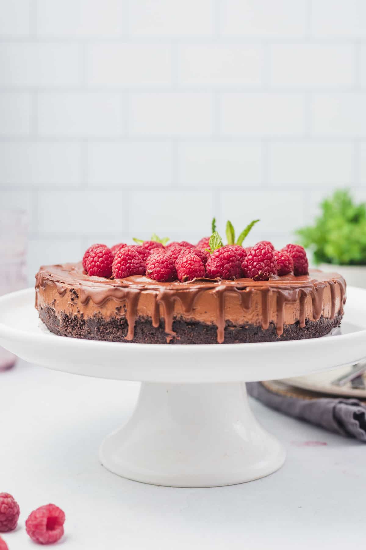 Vegan cake on a white tray with raspberries.