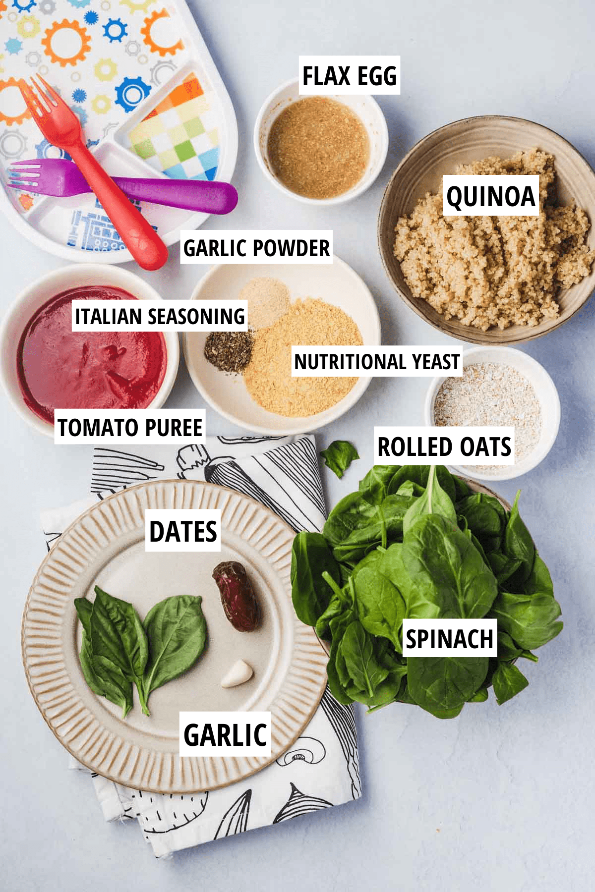 Birds eye view of ingredients, including quinoa, flax egg, seasoning, tomato puree, spinach, dates, garlic, and oats.