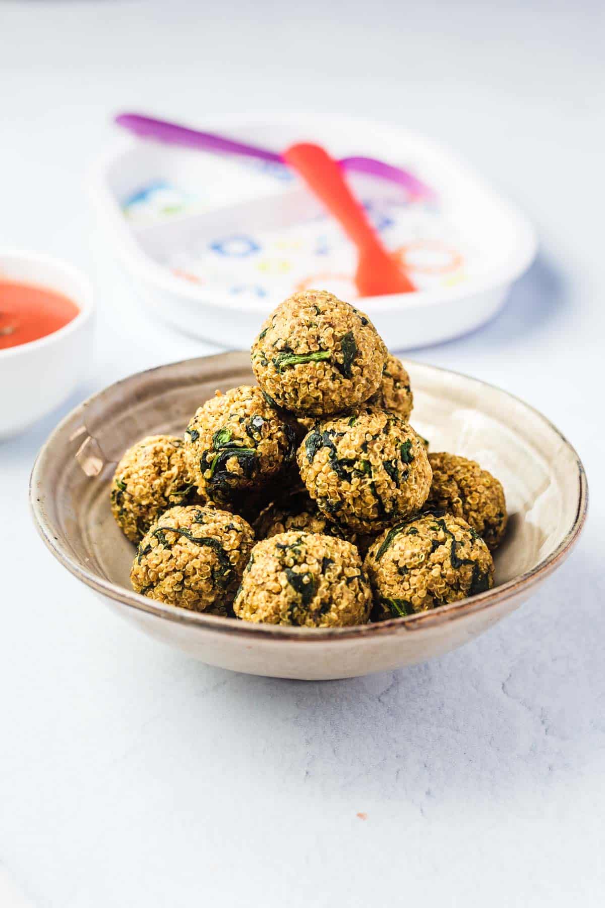 Stack of quinoa balls in a beige bowl.