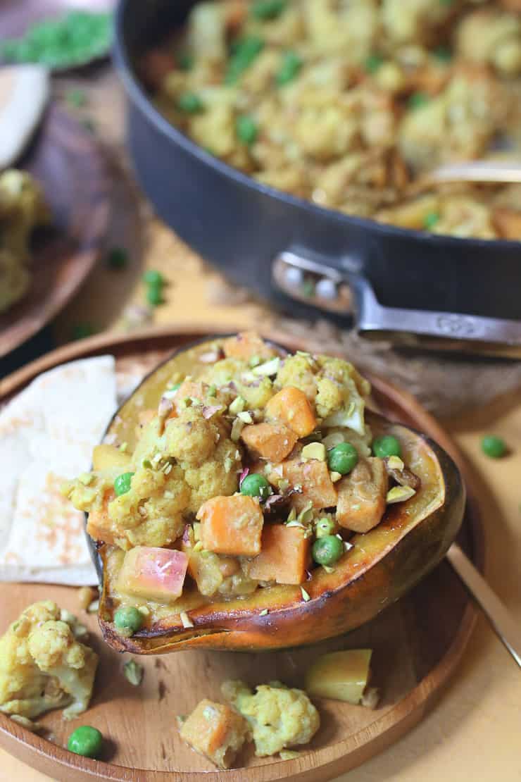 Coconut lentil curry stuffed in an acorn squash on a plate.