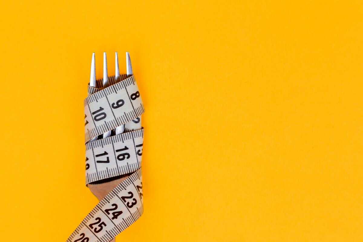 Fork with measuring tape wrapped around it.