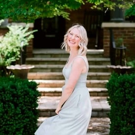 Abbey twirling in a light gray dress.