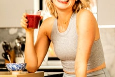 Abbey sitting at the counter with a berry smoothie.