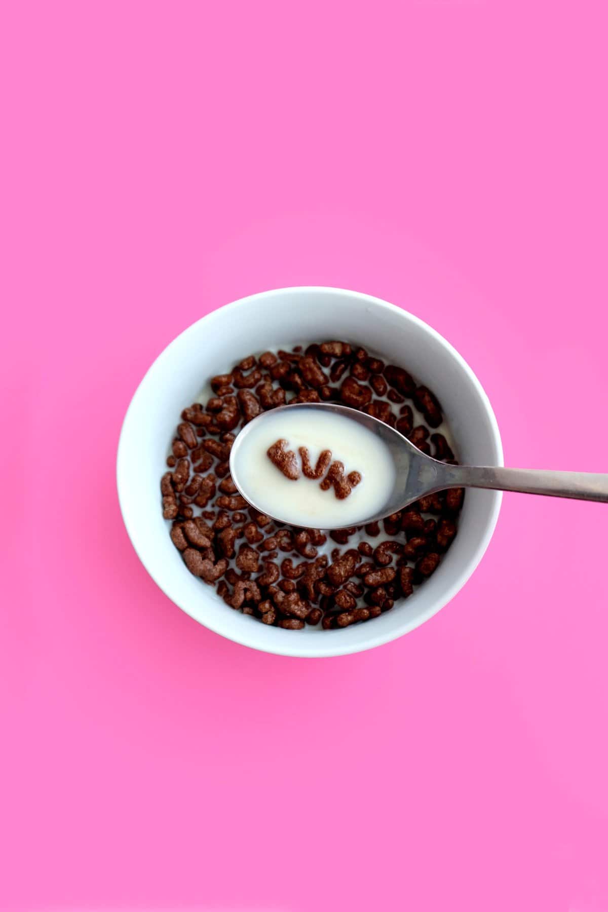 Bowl of cocoa pebbles with the word "fun" spelled out on the spoon.
