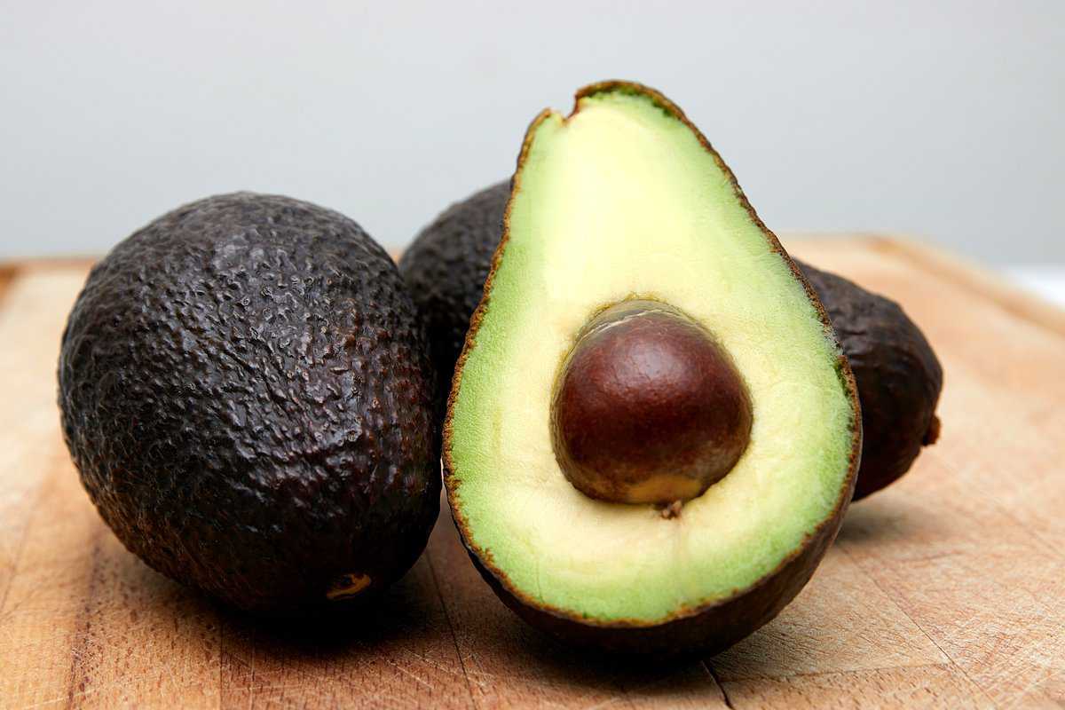 A couple of avocados, one sliced in half.