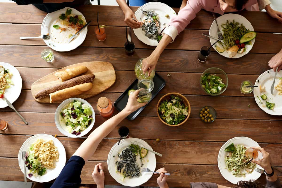 People eating a salad appetizer at a restaurant.