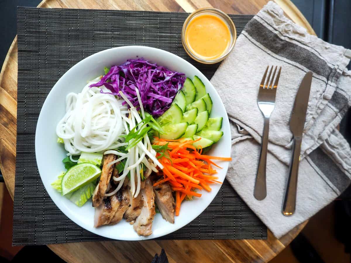 Plate of salad, rice noodles and chicken to show the perfect diet.