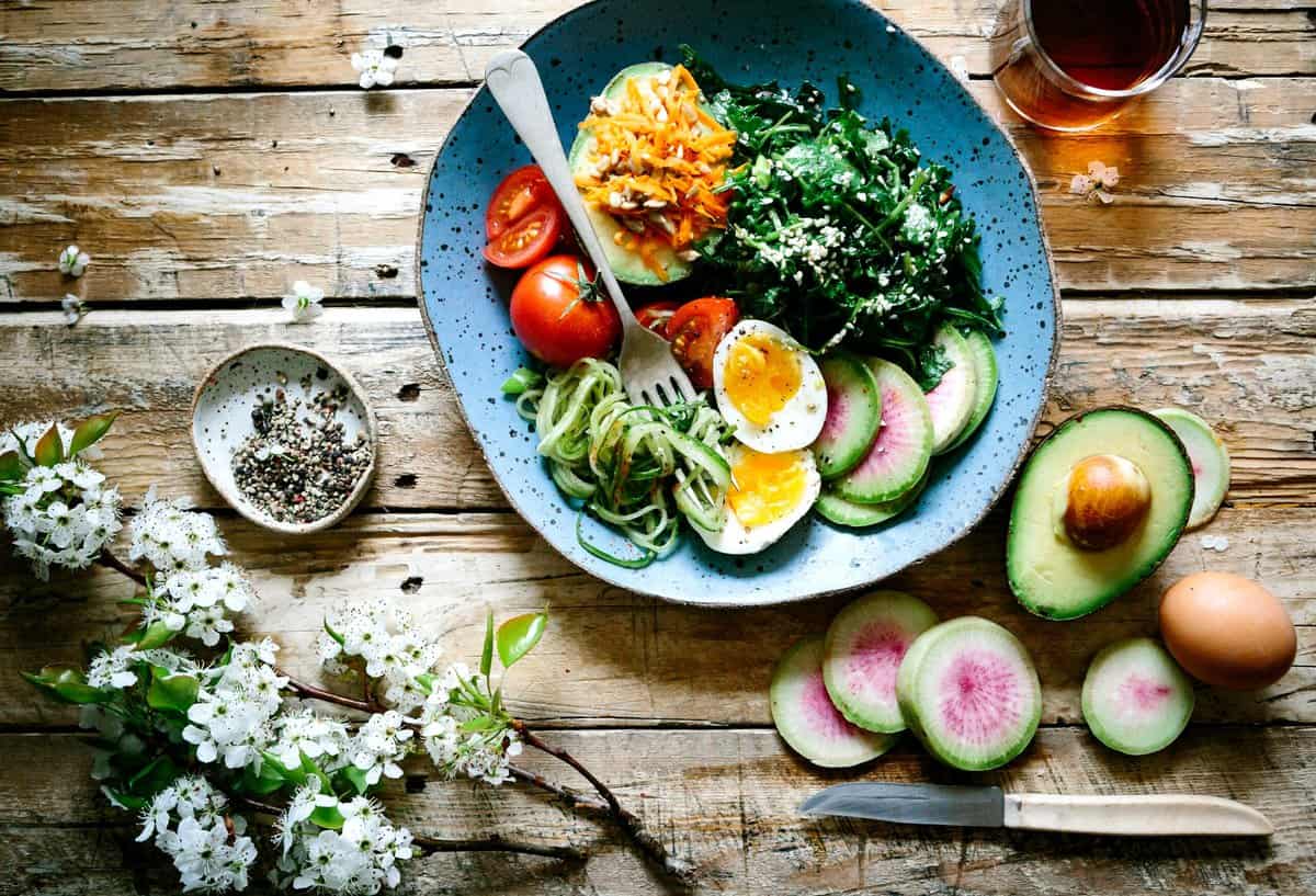 Birdseye view of a salad on a blue plate on a wooden table.