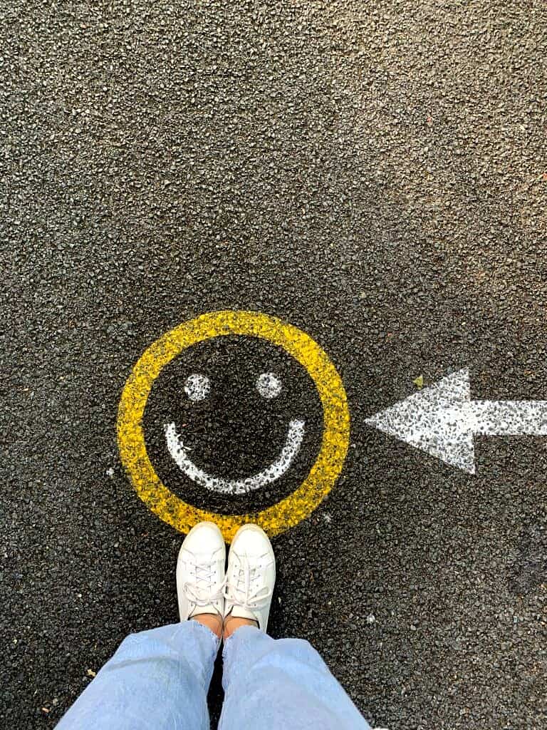Birdseye view of a smiley face painted on a street.