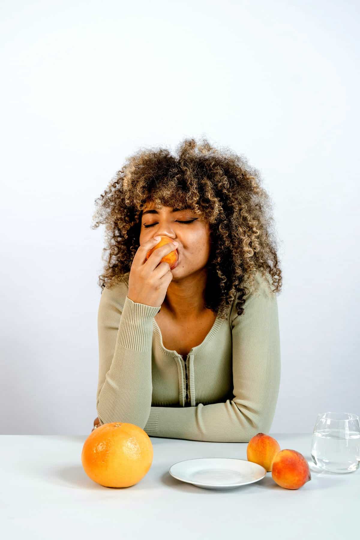 Woman eating an orange on the frugivore diet.