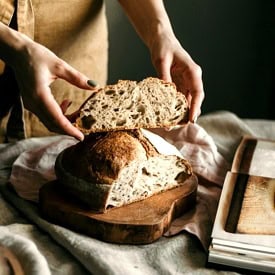 Trad wife influencer holding sourdough bread.