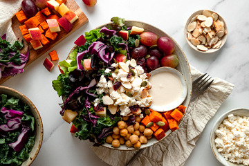 Bowl of tahini crunch salad with grapes, feta, chickpeas, sweet potato and tahini greek yogurt dressing.