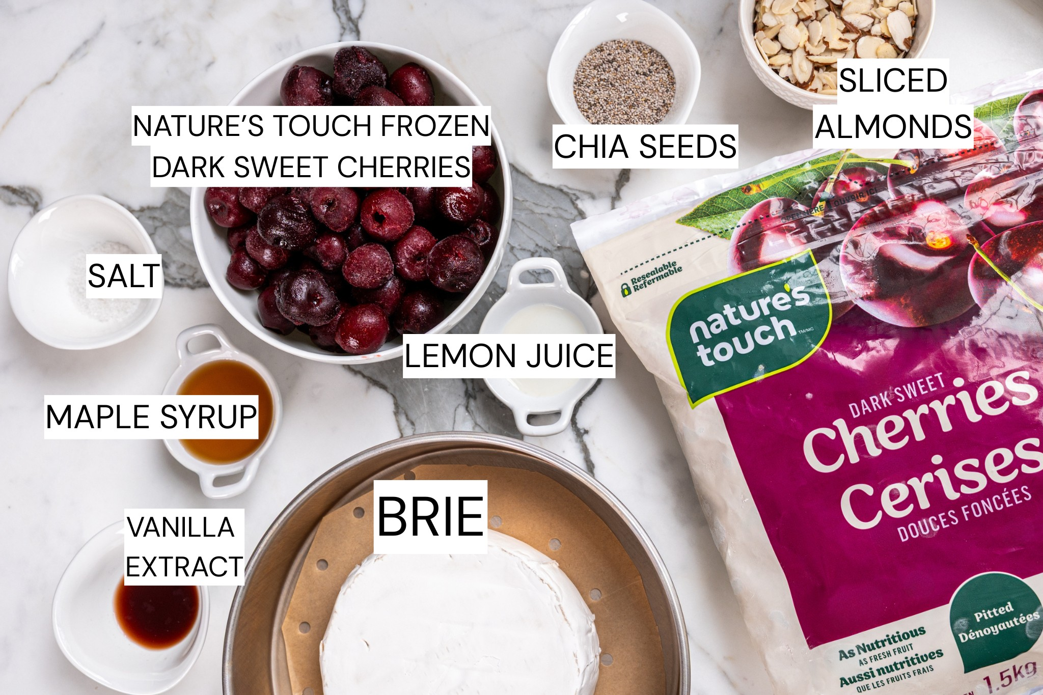 Birds eye of ingredients including Nature's Touch frozen dark sweet cherries, chia seeds, sliced almonds, lemon juice, brie, vanilla extract, maple syrup and salt.