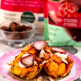 Close up of three tropical french toast muffins, topped with chocolate covered strawberries.