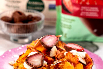 Close up of three tropical french toast muffins, topped with chocolate covered strawberries.
