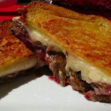 A duck grilled cheese sandwich cut in half, showing the inside.