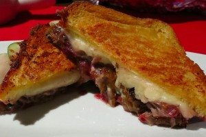 A duck grilled cheese sandwich cut in half, showing the inside.