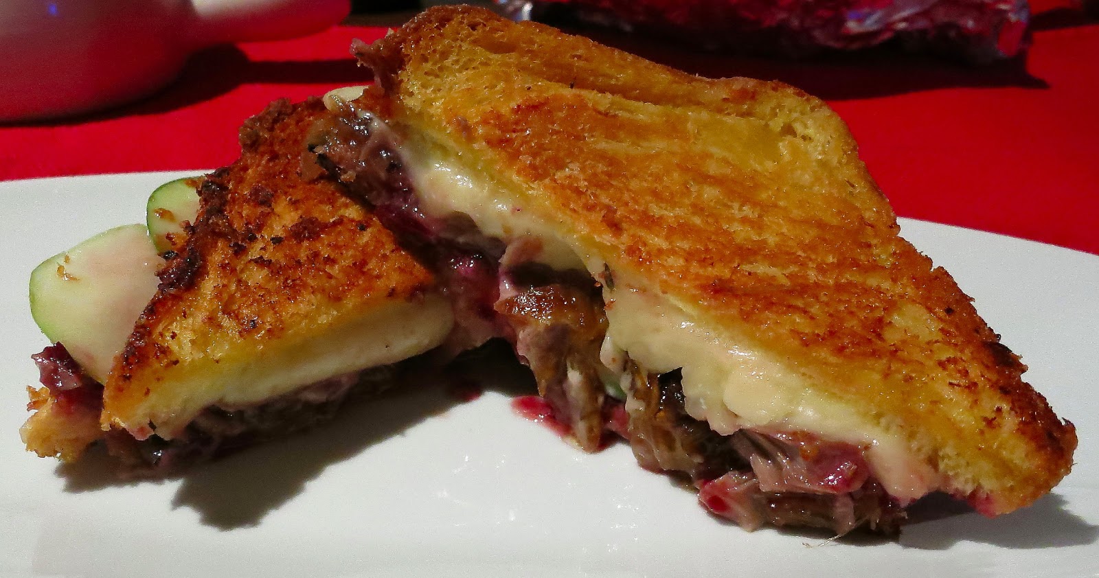 A duck grilled cheese sandwich cut in half, showing the inside.