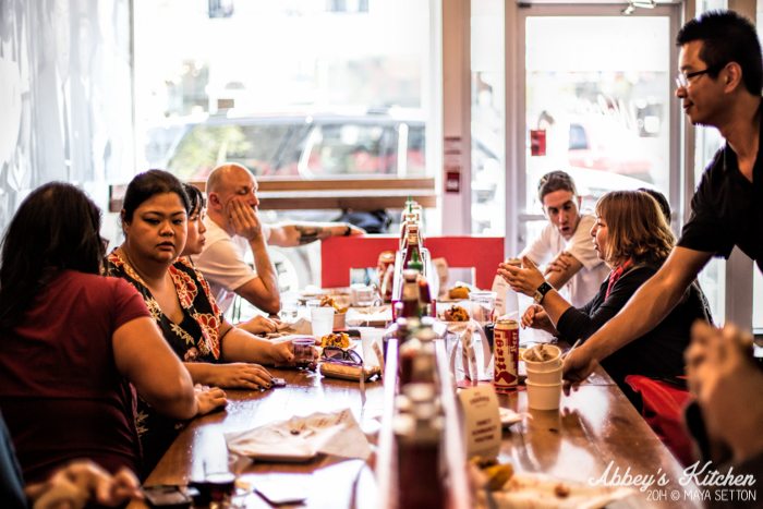 A ground of people sitting at a table, eating and chatting.