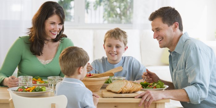 family sitting around a table eating a meal