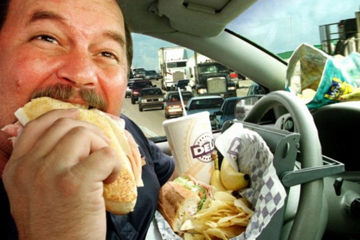 person eating fast food in a car