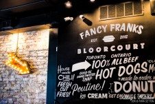 Fancy Frank's Gourmet Hot Dog's wall art and menu.