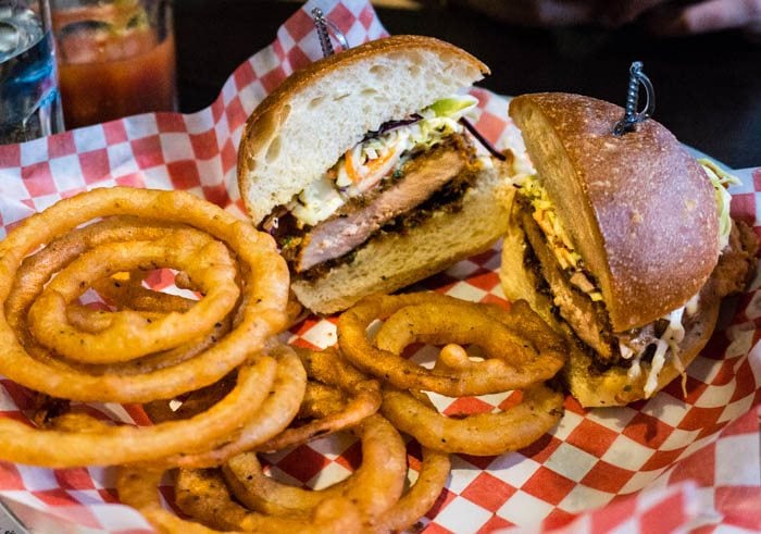 Fried chicken sandwich served with onion rings.