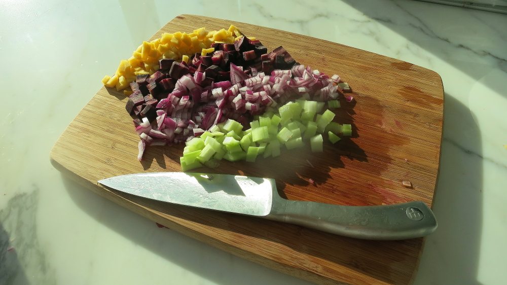 Ingredients for stuffed bell peppers being chopped.