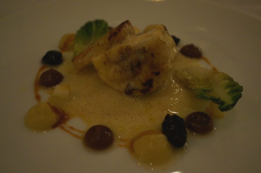 A plate of monkfish with grapes and apples.