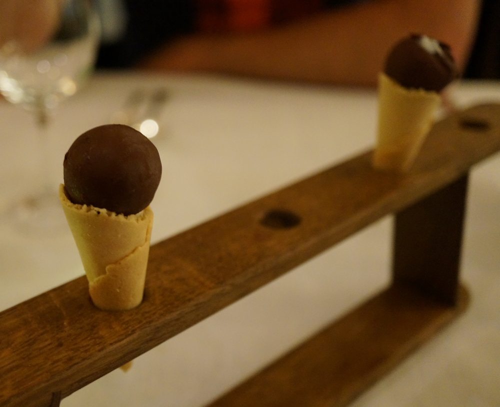 Two mini ice creams on a wooden ice cream holder.